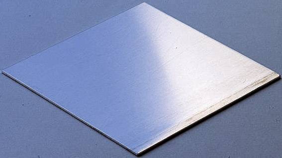 Ein glänzendes, flaches Quadrat aus Metall liegt auf einer glatten, blauen Oberfläche. Die rechte Seite wirft einen Schatten.