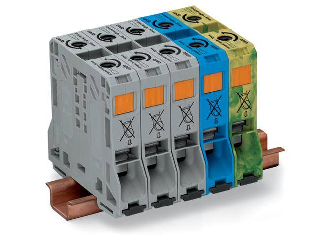 Vier elektrische Sicherungsautomaten auf einer Schiene montiert, in Grau, Blau und Grün. Die Geräte sind für Stromkreissicherung.