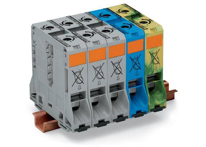 Vier nebeneinander montierte Sicherungstrenner in verschiedenen Farben auf einer Hutschiene, symbolisieren elektrische Schutzschalter.