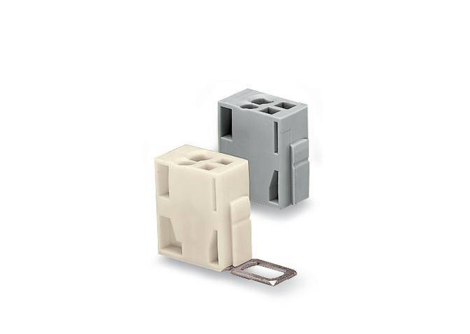 Zwei rechteckige Kunststoffbauteile, beige und grau, mit quadratischen Öffnungen. Ein Metallclip ist am beigen Bauteil befestigt.