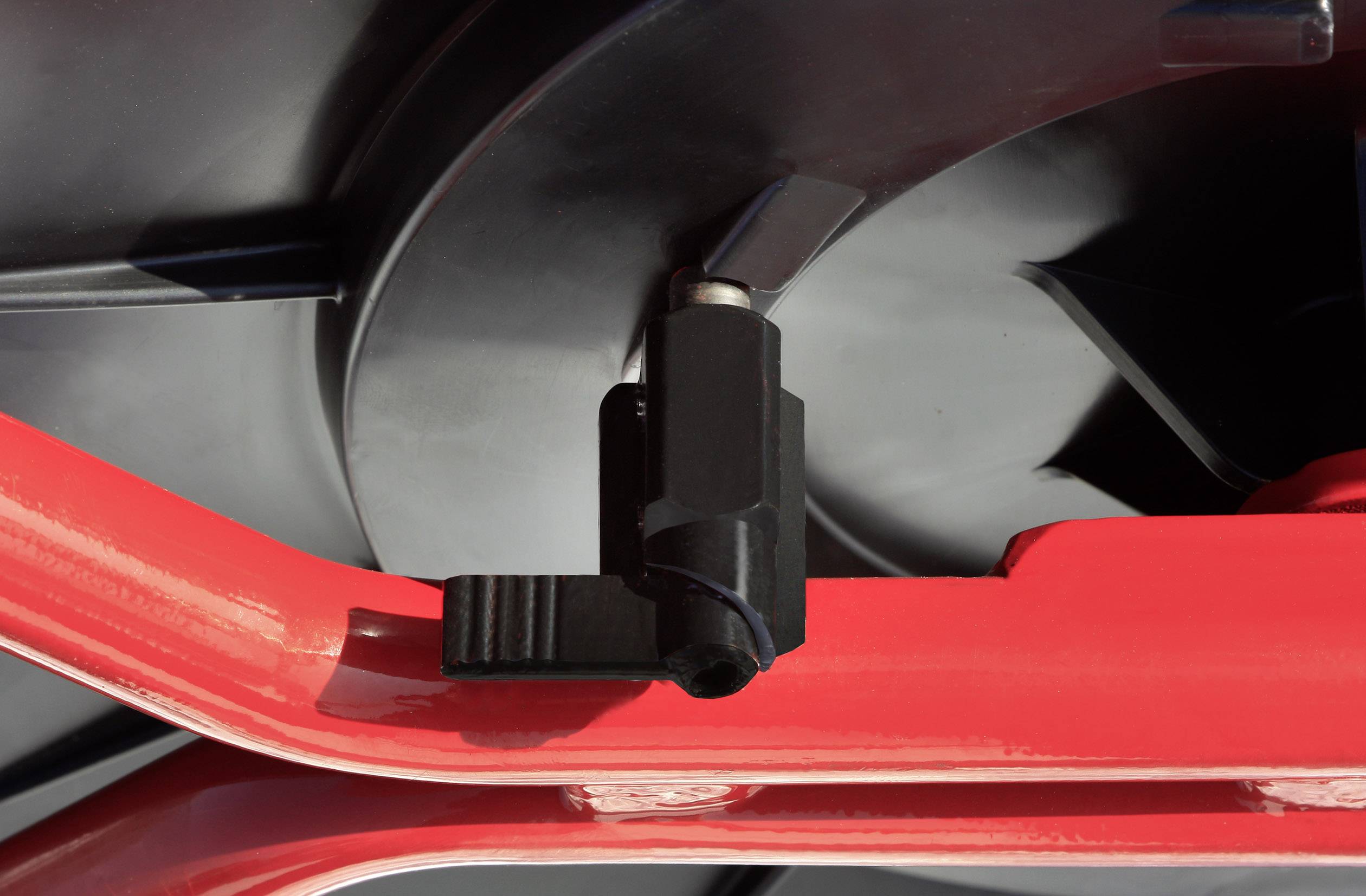 Nahaufnahme eines Teils einer Maschine mit schwarzer und roter Komponente. Die schwarze Komponente ist an der roten Struktur befestigt.