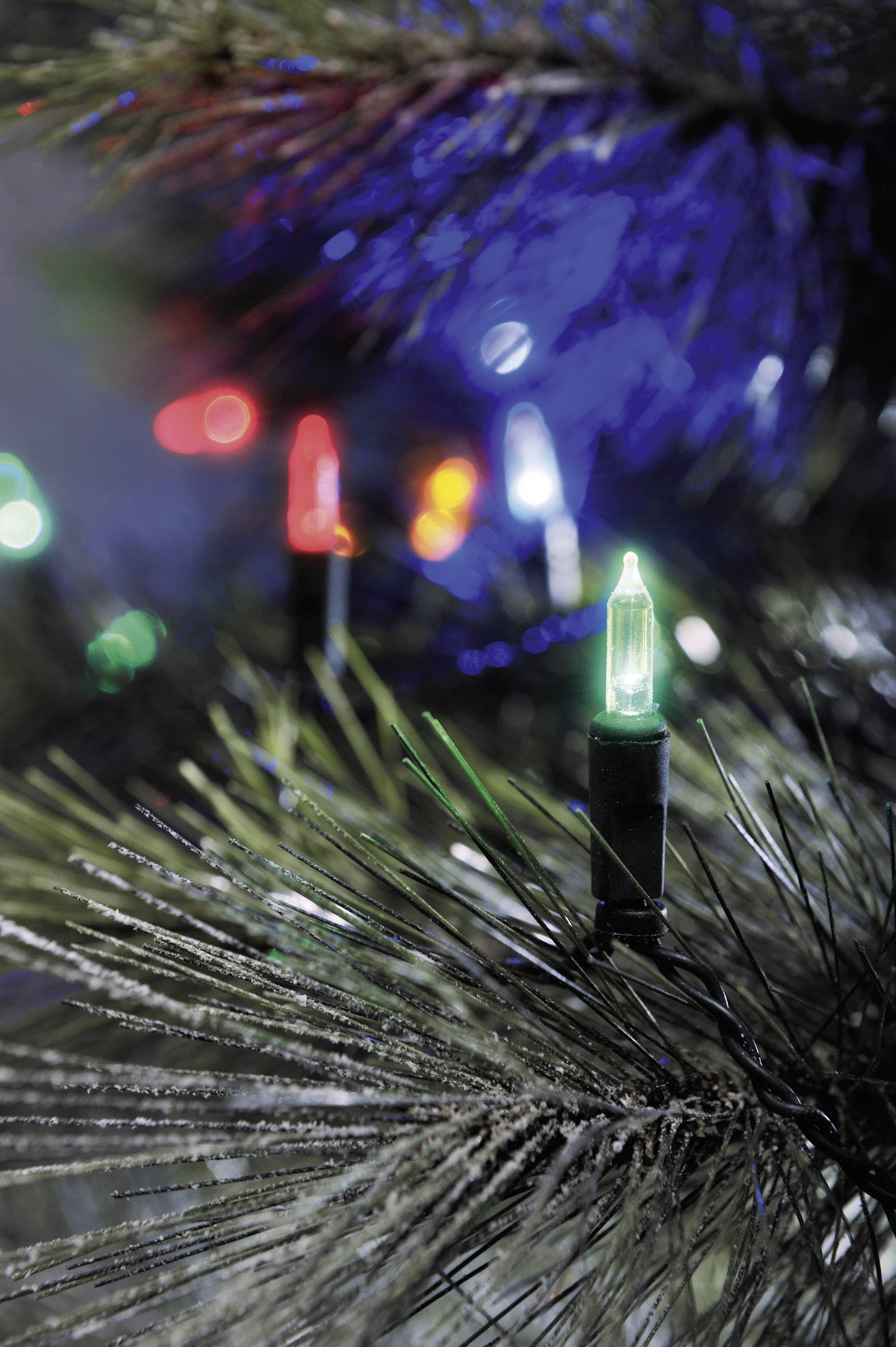 Bunte Lichter an einem Tannenbaum, grünes, rotes und weißes Licht leuchten zwischen den Zweigen, festliche Stimmung.