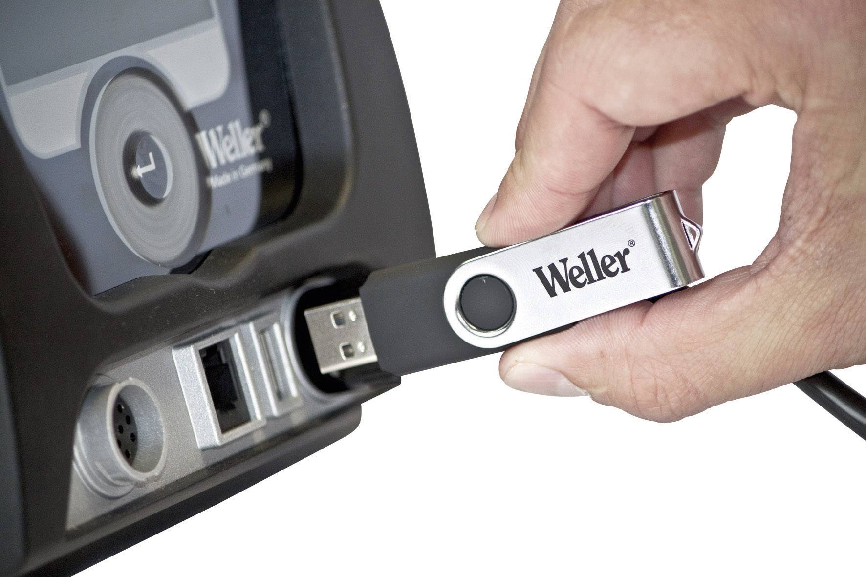 'Ein Hand steckt einen USB-Stick mit der Aufschrift 