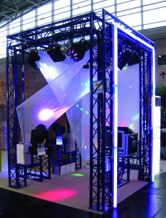 Eine Ausstellungsinstallation mit einem blauen Metallrahmen, Beleuchtungseffekten und audiovisueller Technik in einem Messeumfeld.