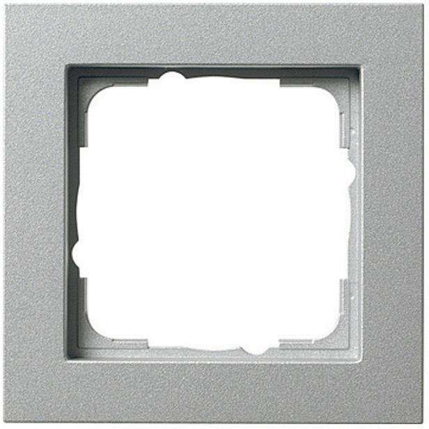 Silberner quadratischer Rahmen mit leerem Innenbereich, vermutlich für Lichtschalter oder Steckdose. Schlichtes Design, metallische Optik.