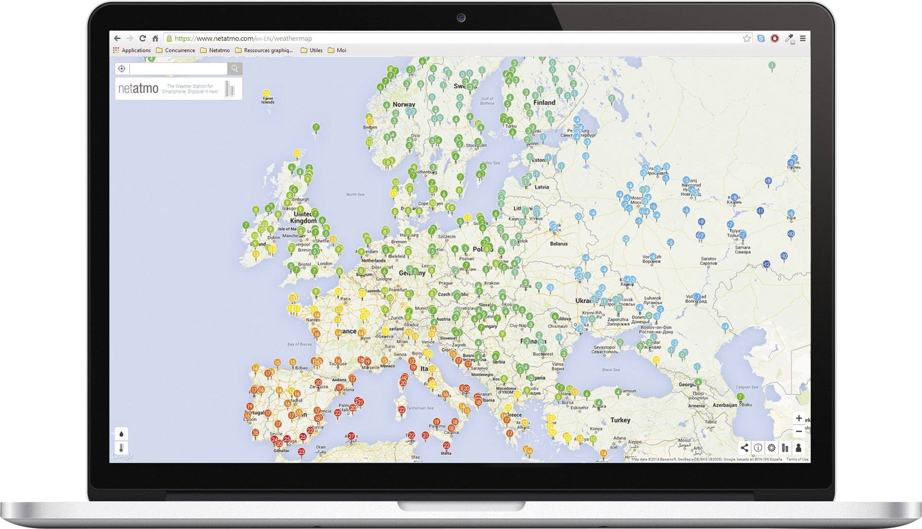 Karte von Europa auf einem Laptop-Bildschirm, zeigt farblich kodierte Marker in verschiedenen Ländern für Wetterstationen oder ähnliche Daten.