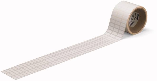 Eine Rolle weißes Klebeband mit kleinen Quadraten, die in gleichmäßigen Reihen angeordnet sind.