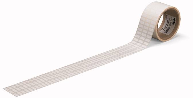 Eine Rolle weißes Klebeband mit quadratischen Markierungen wird von links nach rechts abgerollt.