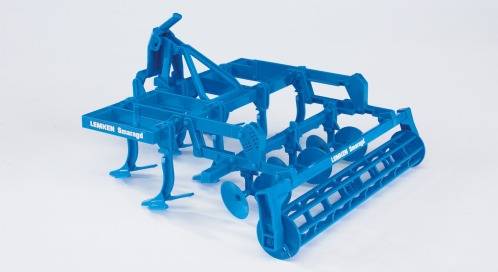 Ein blauer landwirtschaftlicher Bodenbearbeitungsgerät, ein Grubber, mit mehreren Zinken und Rollen, zur Vorbereitung von Feldern.