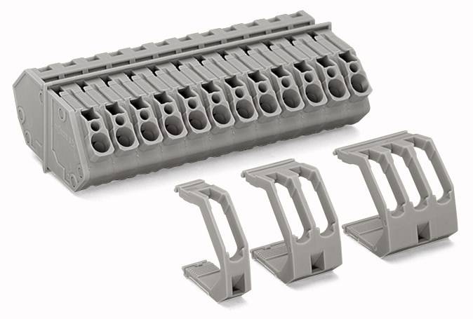 Graues Bauteil mit mehreren Steckplätzen und drei einzelnen passenden Halterungen rechts. Industriezusammenhang wahrscheinlich.