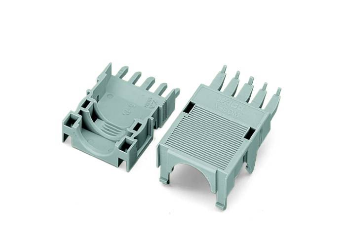 Zwei graue Kunststoffteile eines Kabelclips, offen gelegt und mit Rippenstruktur. Dienen zum Zusammenhalten von Kabeln.