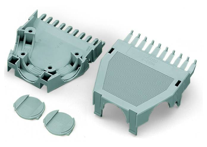 Zwei graue Kunststoffgehäusehälften eines Elektronikgehäuses mit geripptem Design und zwei runde Abdeckungen, auseinandergelegt.