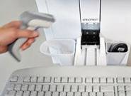 Hand hält Barcode-Scanner über Tastatur vor Scanner-Gerät.