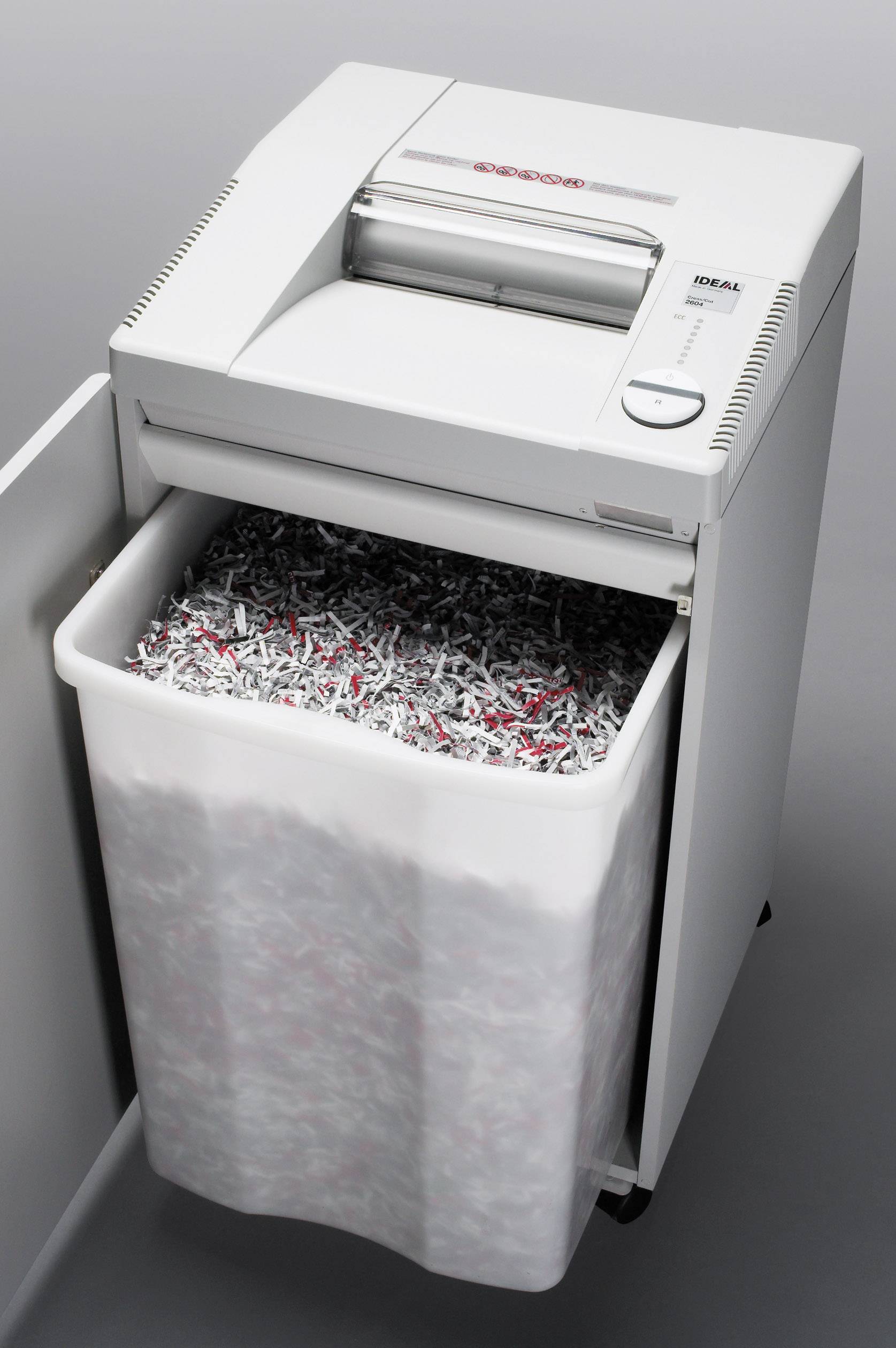 Papier Schredder mit geöffnetem Behälter voller geschredderter Dokumente.