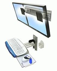 Computersetup mit zwei Monitoren an einer Wandhalterung, Tastatur und Maus auf einer beweglichen Ablage, zeigt eine platzsparende Lösung.