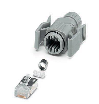 Graues RJ45-Steckergehäuse mit Einzelteilen; links daneben befindet sich ein metallischer Steckerteil, eine kleine silberne Hülse und ein Kunststoffwieger.