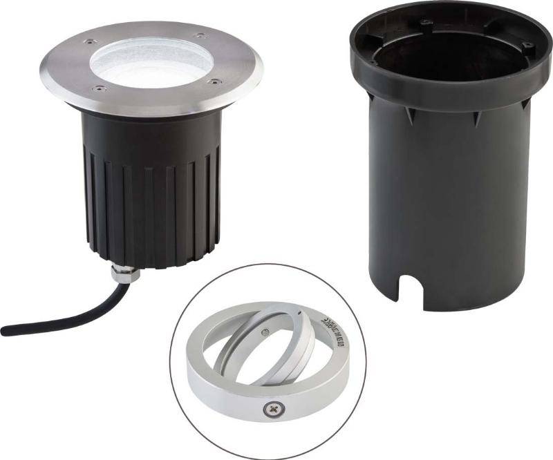 Bodenleuchte und passende Montagehülse: links eine runde LED-Bodenleuchte mit Kabel, rechts eine schwarze Hülse. Vordergrund zeigt Zubehör.