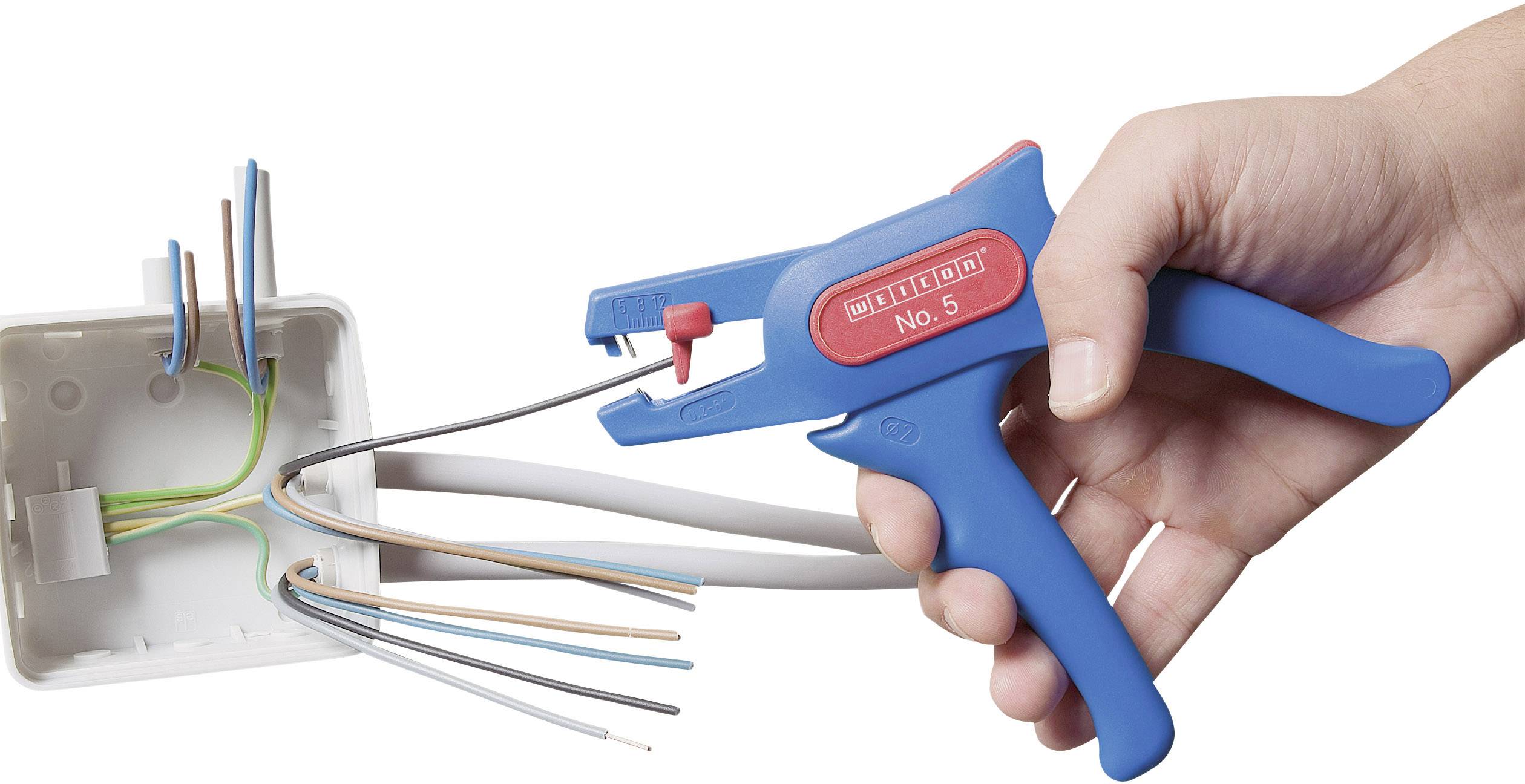 Eine Hand hält eine blaue Abisolierzange, die ein Kabel vor einer Anschlussdose mit mehreren farbigen Drähten abisoliert.