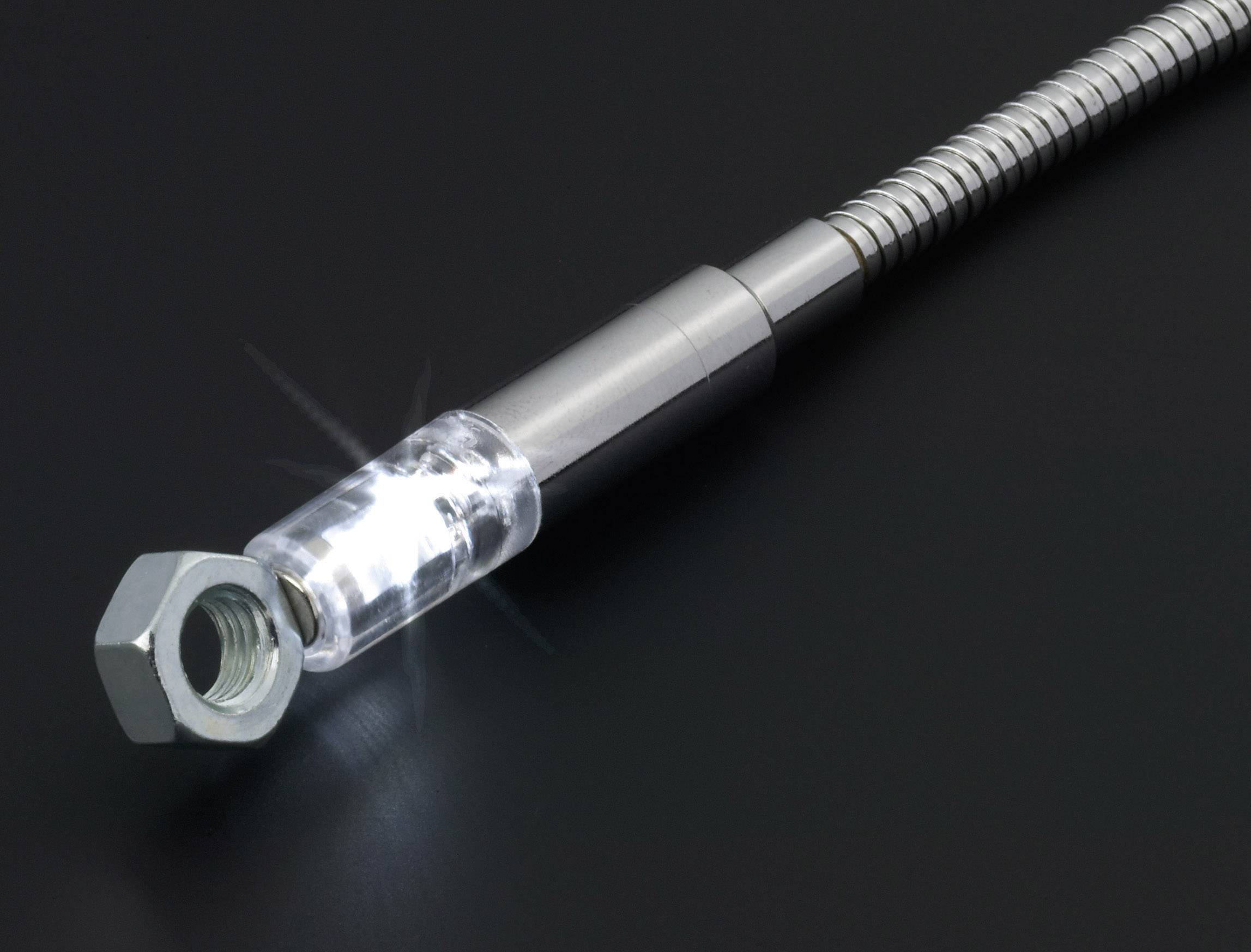 Eine flexible magnetische Stablampe hebt eine Metallmutter an. Sie leuchtet hell auf dunklem Hintergrund.
