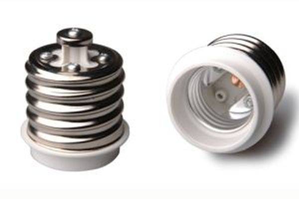 Zwei Adapter auf weißem Hintergrund. Links ein geschlossener Adapter mit metallischen Ringen, rechts ein geöffneter Adapter mit Innenansicht der Kontakte.