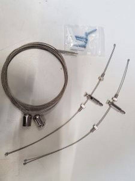 Ein Kabelset mit zwei Kabeln, metallischen Verschlüssen und Schrauben in einer Tüte. Verwendet für Fahrradbremssysteme.