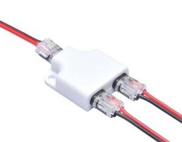 Roter und schwarzer LED-Verbinder, auf weißem Hintergrund liegend, zeigt die Verbindung von LED-Streifen mit Stromkabeln.