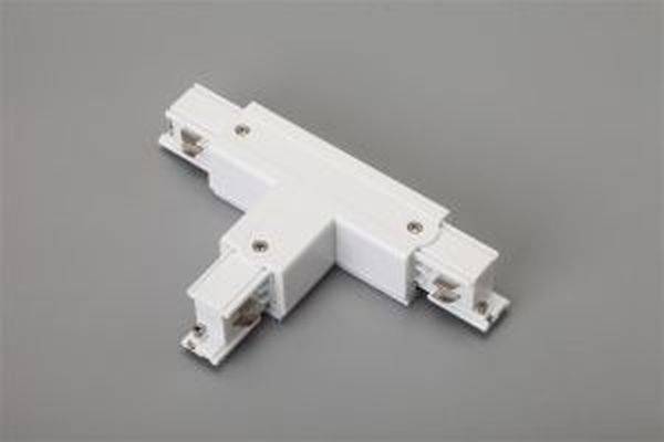 Ein weißer, T-förmiger elektrischer Verbinder auf grauem Hintergrund, verwendet zur Verbindung von Beleuchtungsschienen in drei Richtungen.