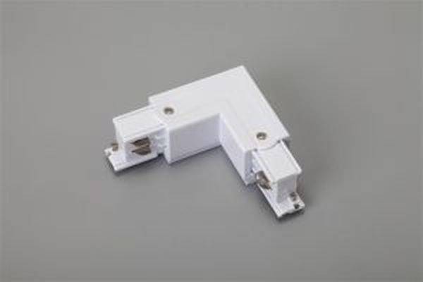 Ein weißer L-förmiger elektrischer Adapter auf grauem Hintergrund, mit Schrauben an der Innenseite zur Befestigung.