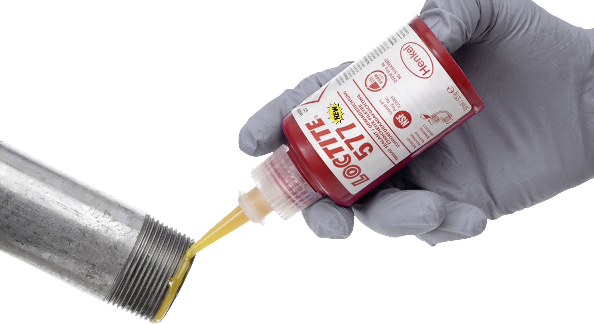 Eine behandschuhte Hand trägt anaeroben Dichtstoff 'Loctite 577' auf ein metallisches Gewinderohr auf.
