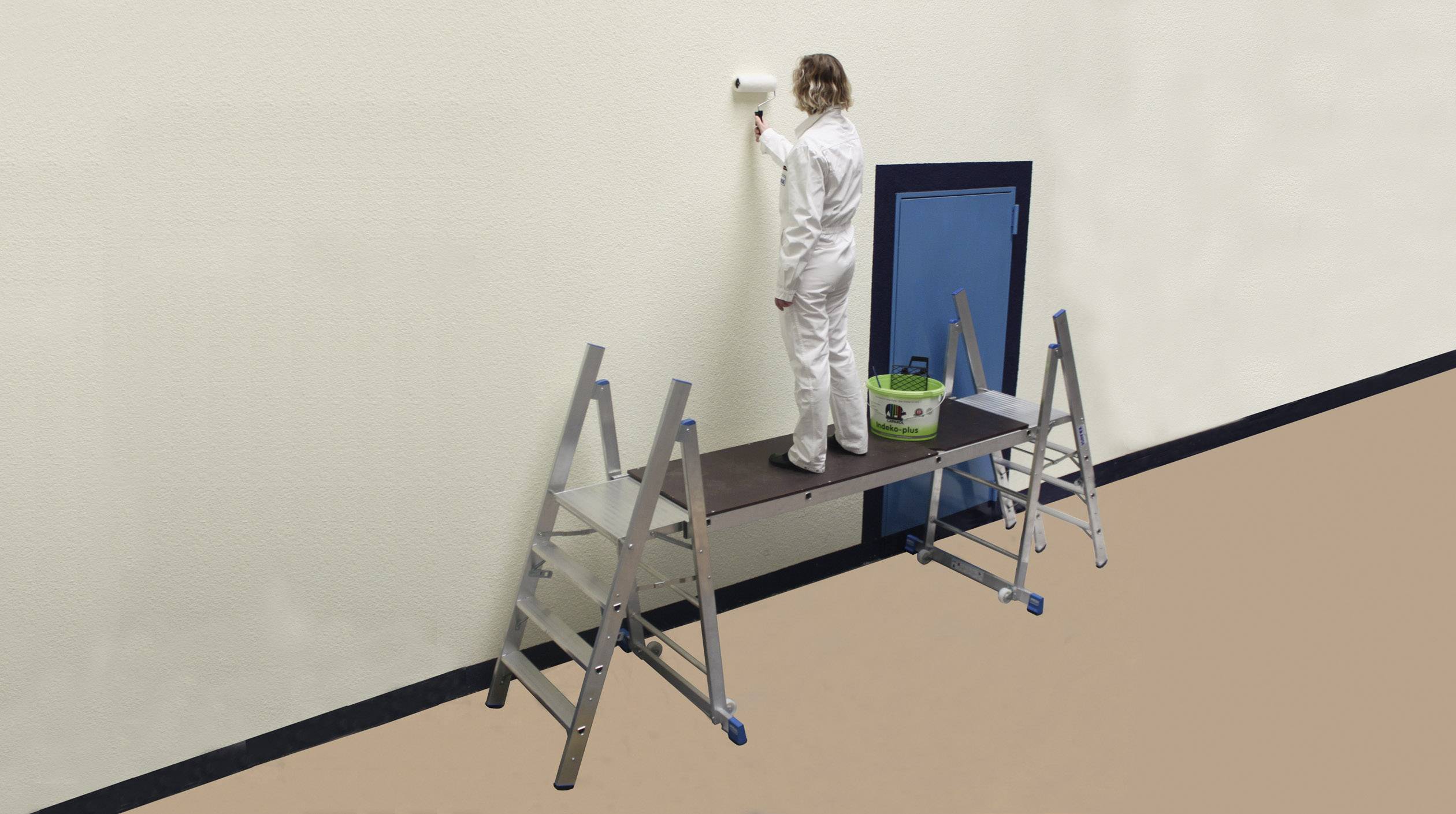 Eine Person in weißem Maleroverall steht auf einem zusammengebauten Gerüst aus zwei Leitern, um eine Wand zu streichen.