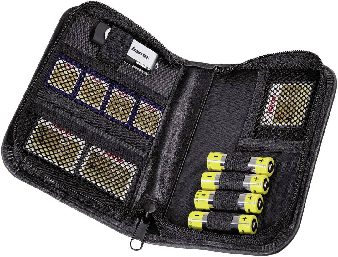 Offene schwarze Tasche mit Speicherkarten und Batterien in Netztaschen. Oben links befindet sich ein silberfarbener USB-Stick.