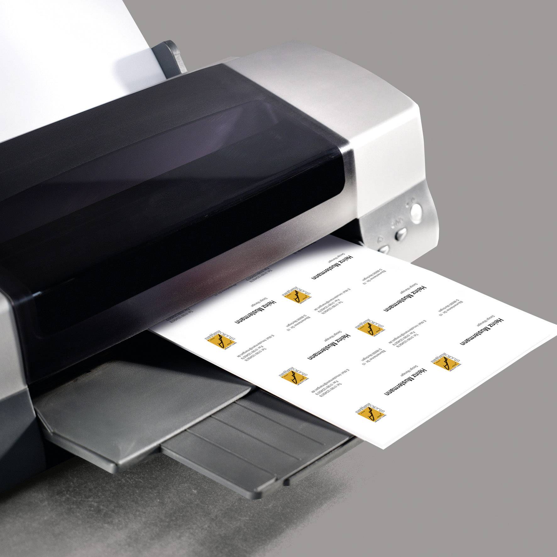 Ein Drucker druckt ein Blatt mit mehrmals wiederholtem orangem Grafikdesign und Text in kleinen Kästchen auf weißem Papier.