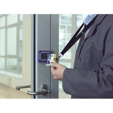 Eine Person mit einem Umhängeband benutzt eine Zugangskarte, um eine Glastür mit elektronischem Tastenfeld zu entsperren.