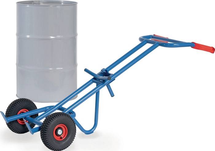 Stahlblauer Stahlfasstrolley mit zwei großen Rädern und rotem Griff neben einem grauen Metallfass auf weißem Hintergrund.