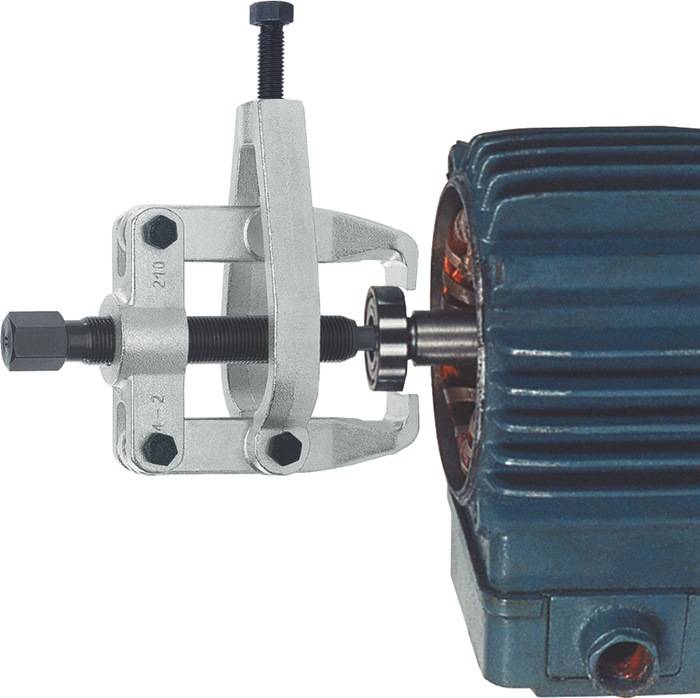 Ein Lagerabzieher wird ein Lager aus dem Gehäuse eines Elektromotors herausziehen. Das Werkzeug umgreift das Lager fest, bereit zur Entfernung.