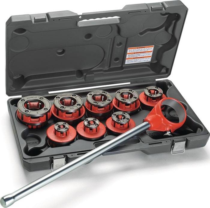 Ein Satz Metallrohrgewindewerkzeuge in einer schwarzen Plastikbox, ausgestattet mit einem langen Griff und mehreren kreisförmigen Schneidbacken zum Gewindeherstellung an Rohren.