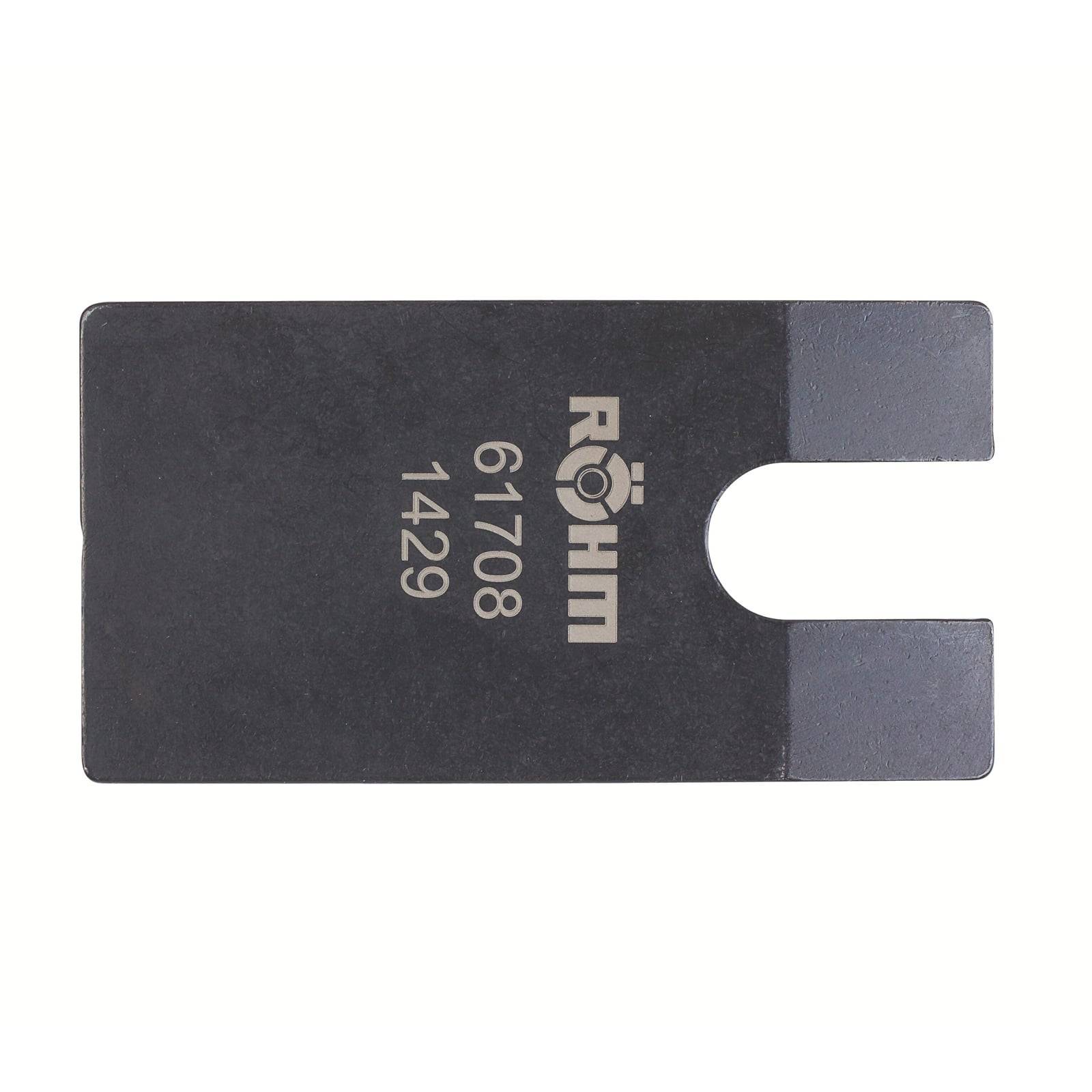 Flaches schwarzes Metallteil mit der Gravur „RÖHM 61708 1429