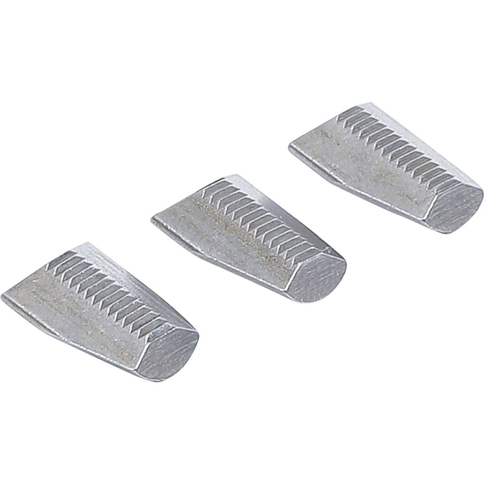 Drei Metallkeile mit strukturierten Oberflächen, nebeneinander auf einem einfarbigen Hintergrund ausgerichtet.