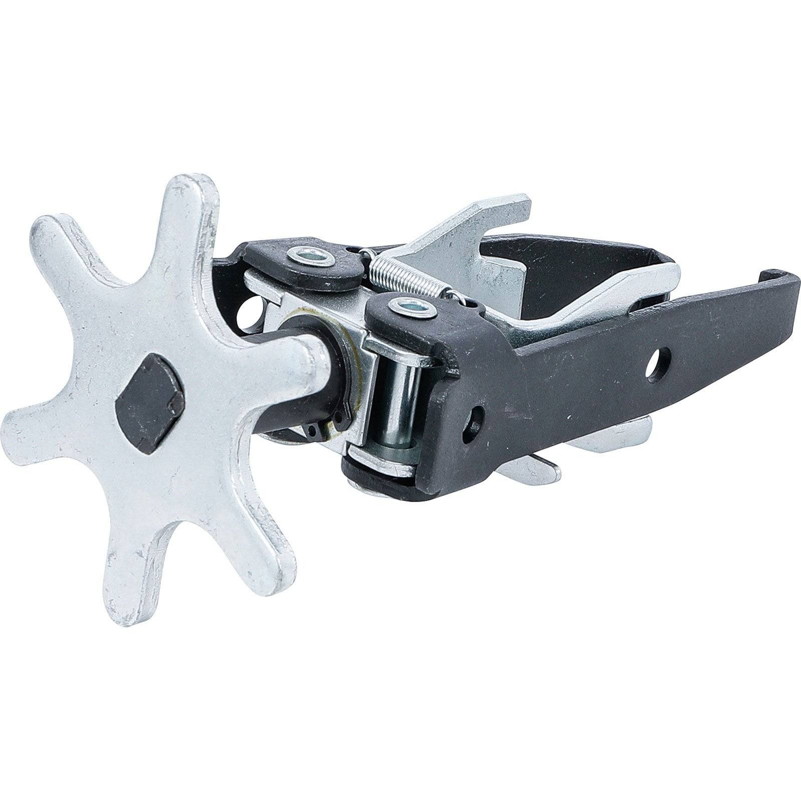 Metallische Ratsche mit sternförmigem Zahnrad und zwei schwarzen Hebeln, verwendet für mechanische Einstellungen oder in Gerüstsystemen.