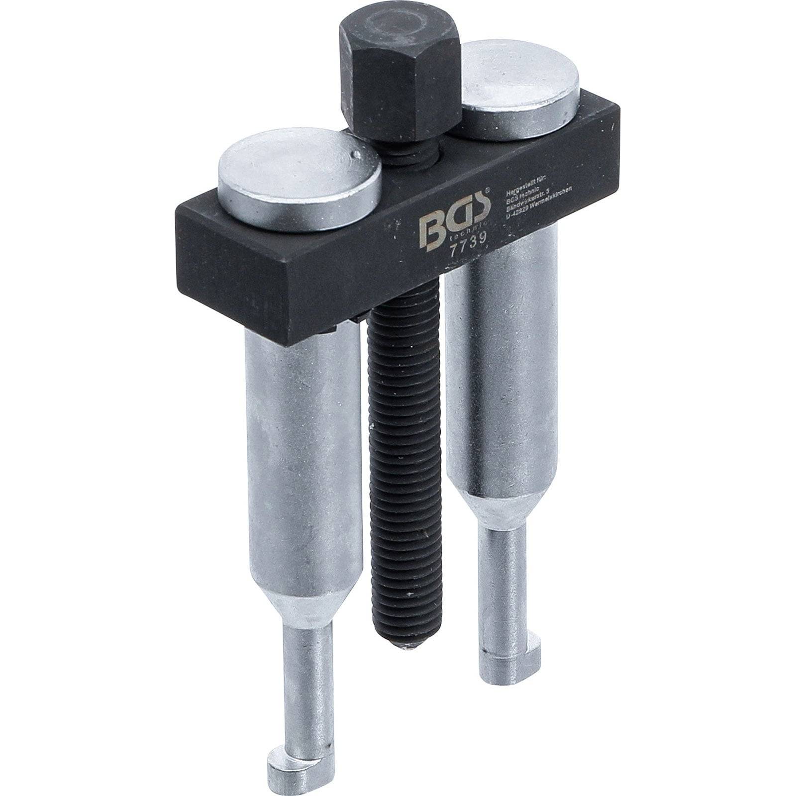 Ein Schraubenausdreher-Werkzeug mit zwei silbernen Armen und einer zentralen schwarzen Schraube, der zum Entfernen von festsitzenden Schrauben verwendet wird.