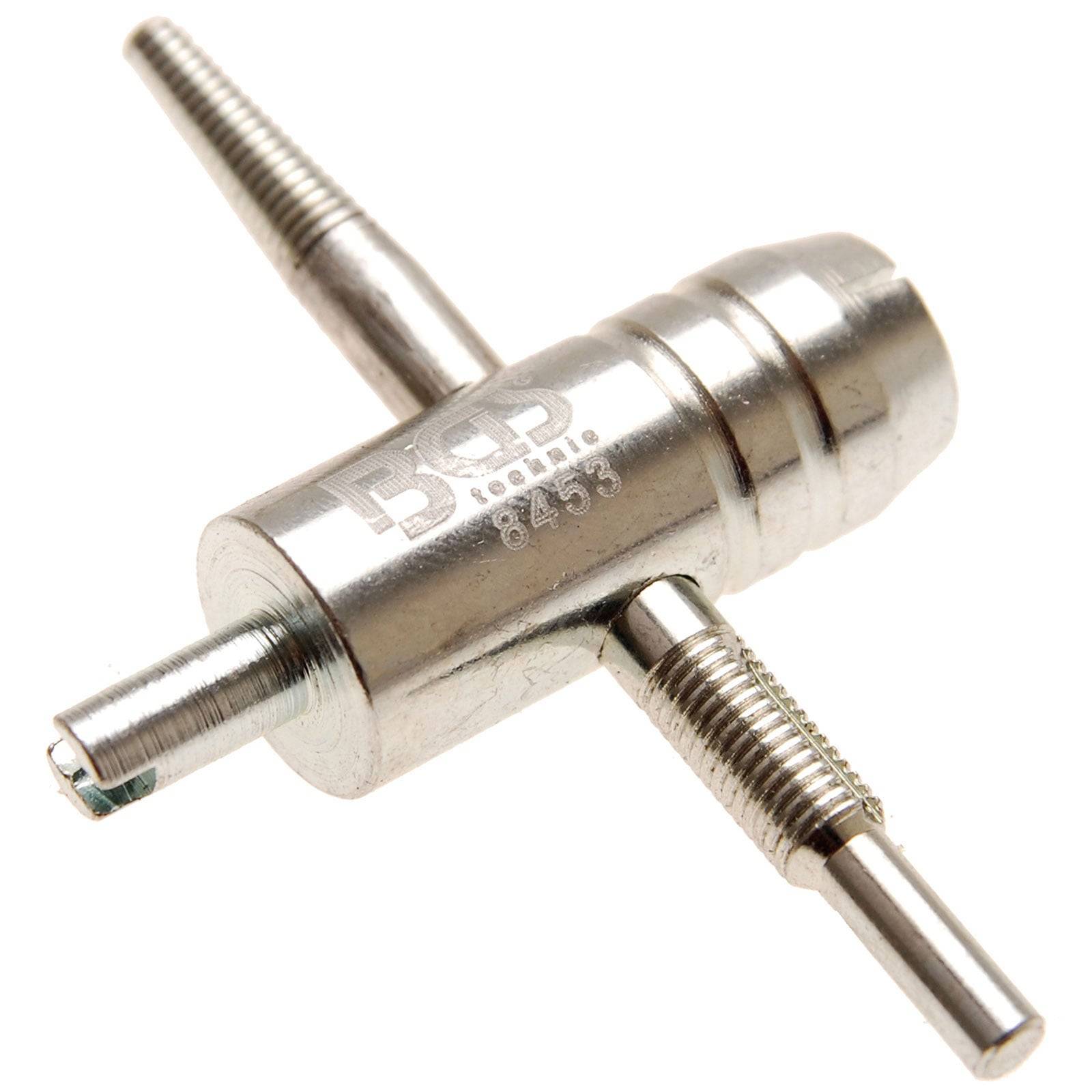 Ein Metalltool mit drei zylindrischen Wellen, die sich kreuzen, graviert mit 'B', 'P' und '8453'. Verwendet zum Justieren oder Zusammenbauen von Teilen.