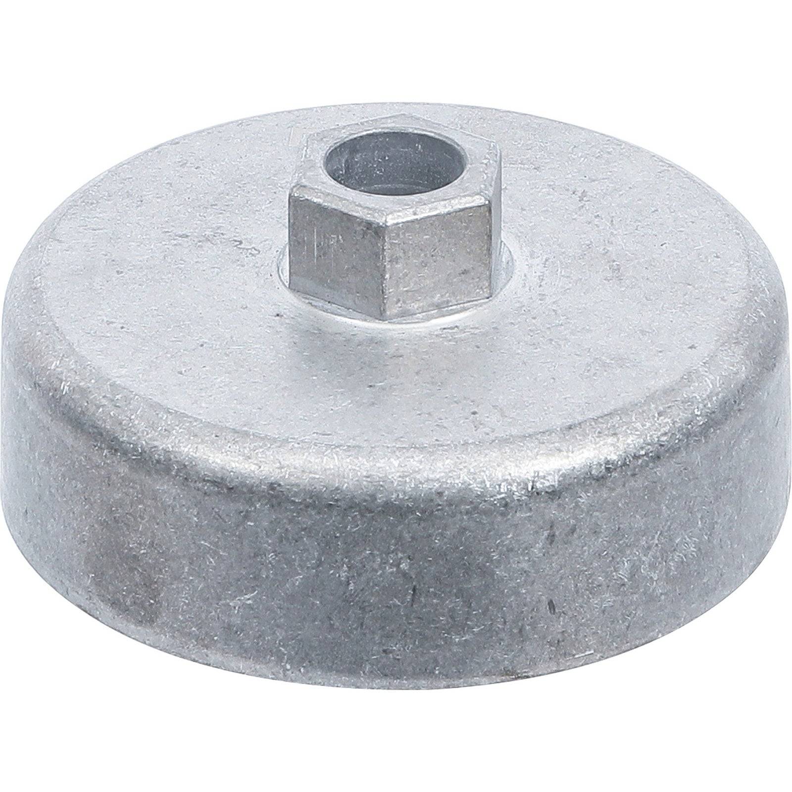 Ein rundes Metallobjekt mit einem sechseckigen Loch in der Mitte, das einer robusten Unterlegscheibe oder einem Abstandshalter ähnelt, auf einem weißen Hintergrund.