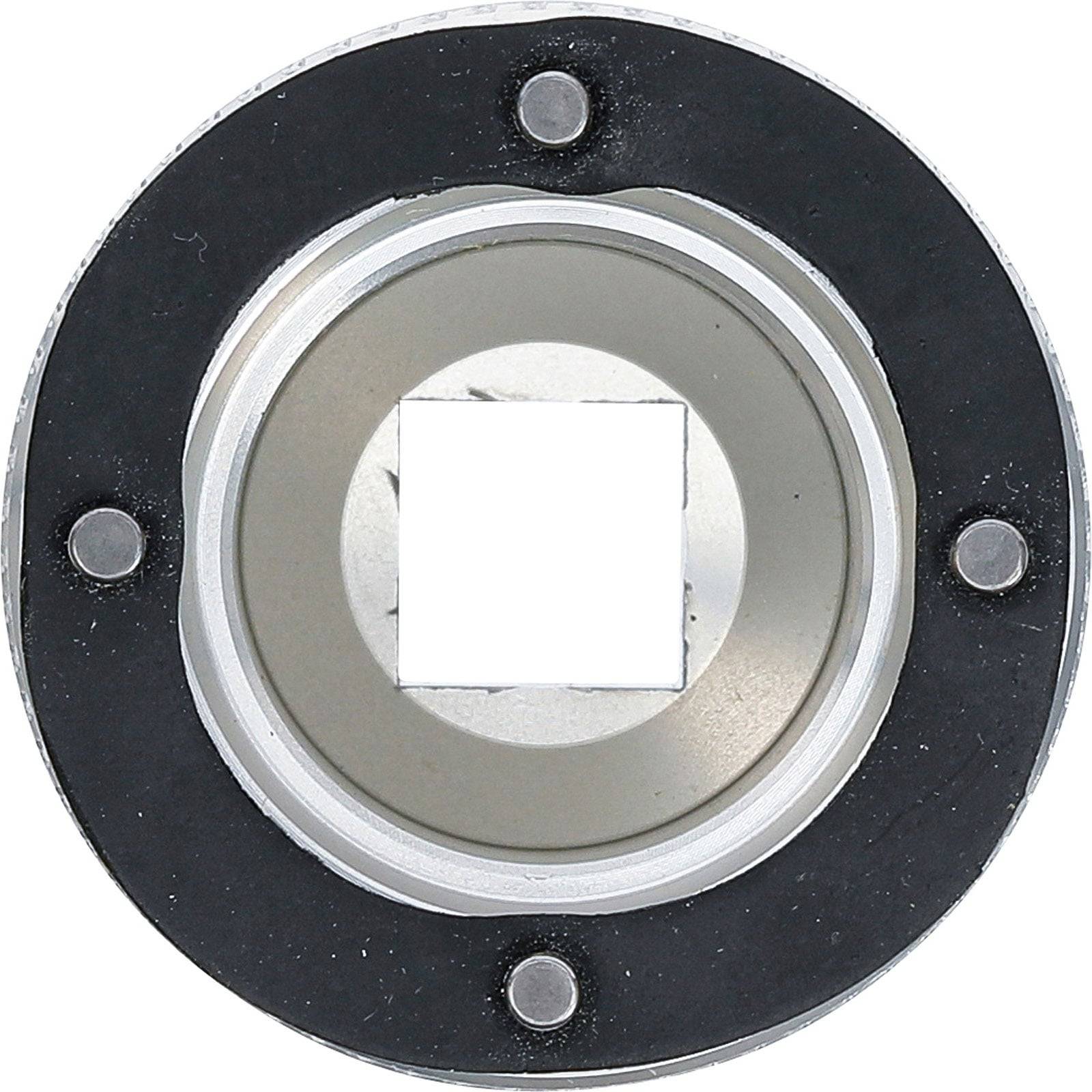 Kreisförmiges Metallobjekt mit einem zentralen quadratischen Ausschnitt, umgeben von vier kleinen kreisförmigen, magnetähnlichen Teilen in gleichen Abständen.