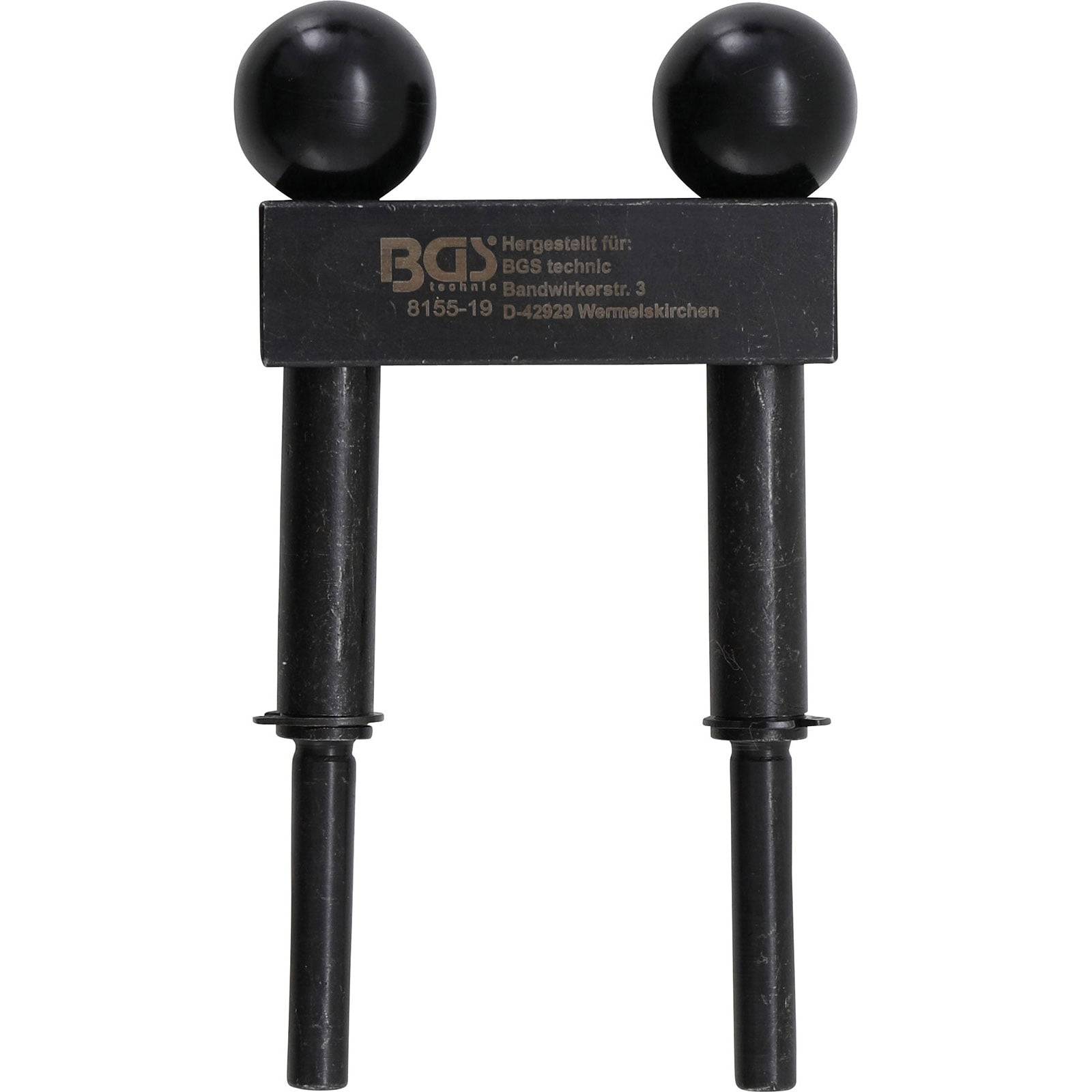 Ein dunkel gefärbtes Metallwerkzeug mit zwei parallelen Stangen und runden Griffen, mit der Aufschrift 