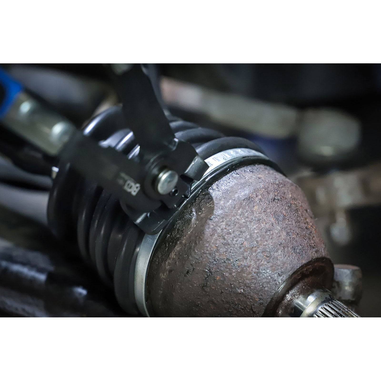 Ein mechanisches Werkzeug justiert ein Metallbauteil mit präzisem Griff, möglicherweise in einem Automobil- oder industriellen Umfeld, und demonstriert technische Wartung.