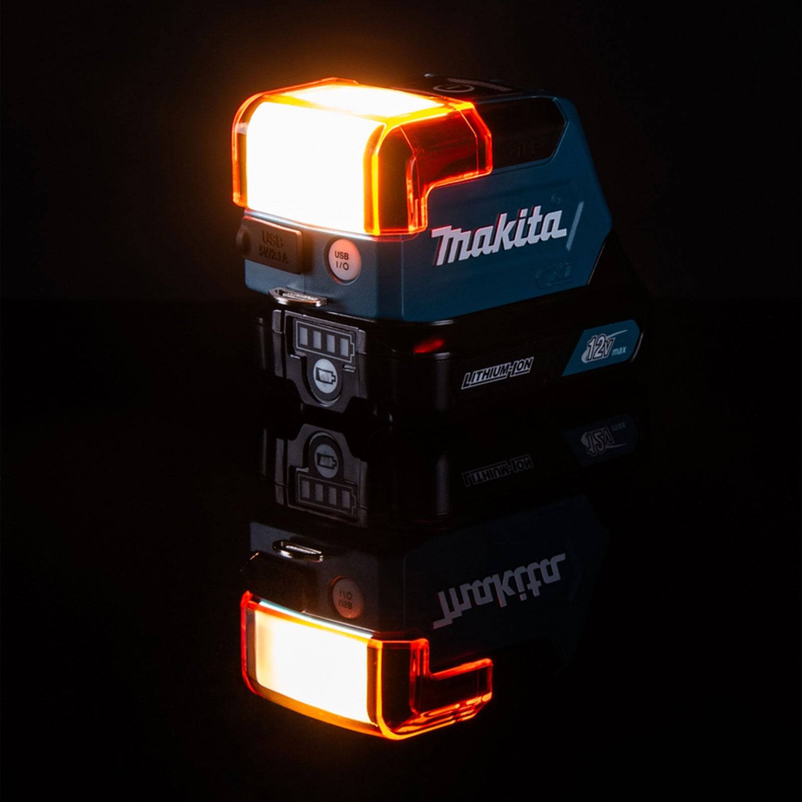 Ein kompaktes blaues und schwarzes Makita-Gerät mit einem orangefarbenen Licht leuchtet hell und zeigt die Beschriftungen 