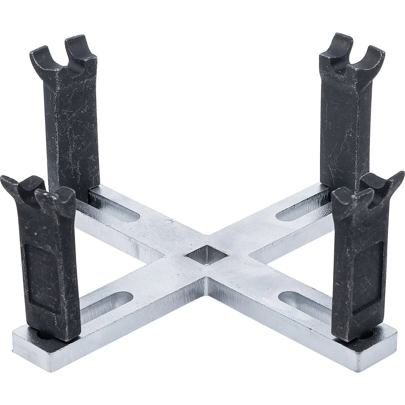 Ein Metallständer in X-Form mit je vier vertikalen schwarzen Spitzen an jedem Ende, verwendet zur Unterstützung oder Befestigung von Objekten.