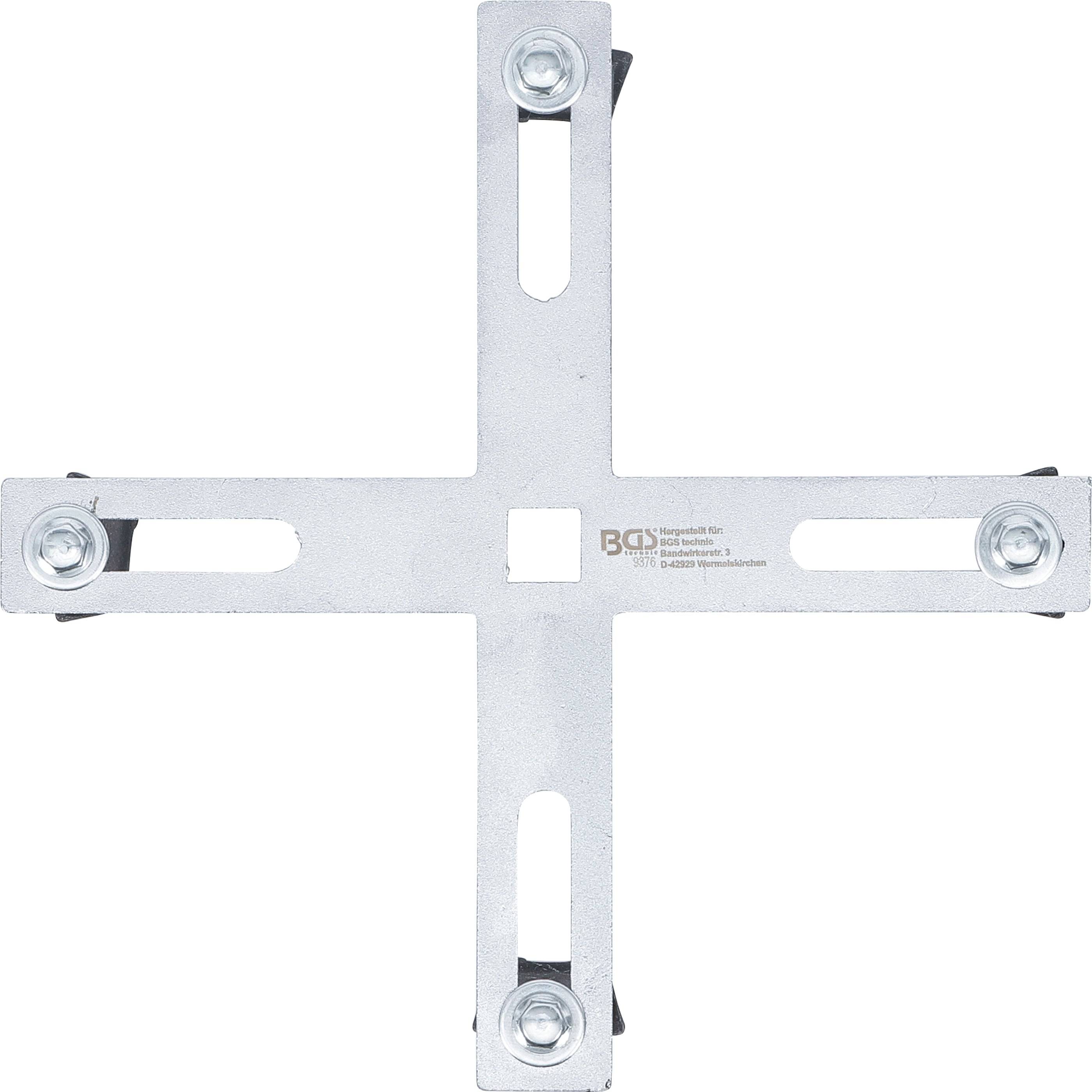 Metallkreuz mit vier verstellbaren Armen, deren jeder in einem Bolzen endet; wahrscheinlich ein Werkzeug oder eine Komponente für mechanische oder industrielle Anwendungen.