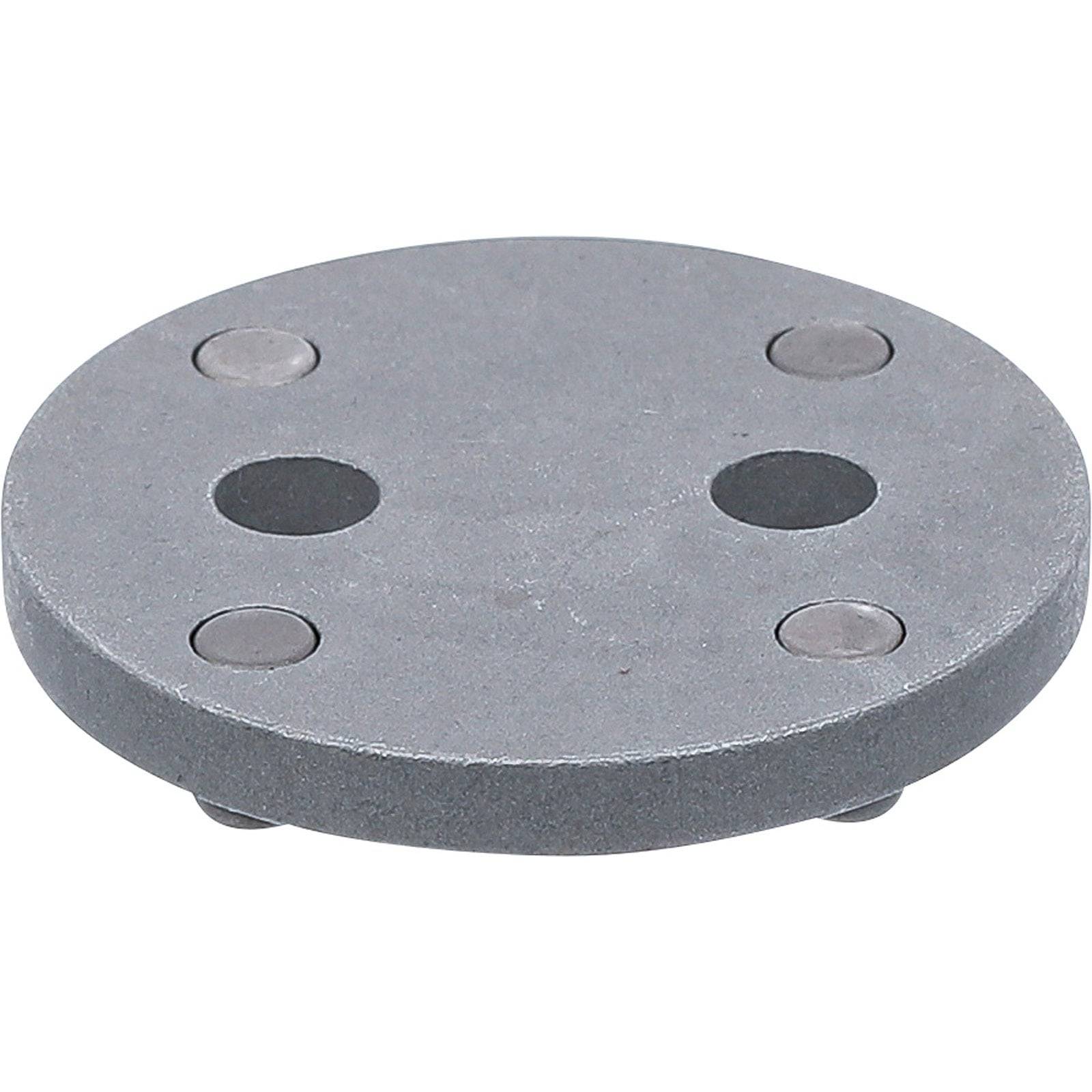 Eine graue runde Metallplatte mit vier kreisförmigen Schlitzen und vier kleinen kreisrunden Magneten an den Kanten.