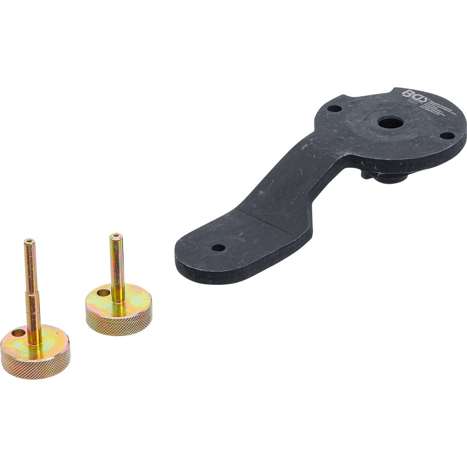 „Ein Nockenwellensperrwerkzeug und zwei Metallstifte, verwendet für Wartung und Ausrichtung von Fahrzeugmotoren.